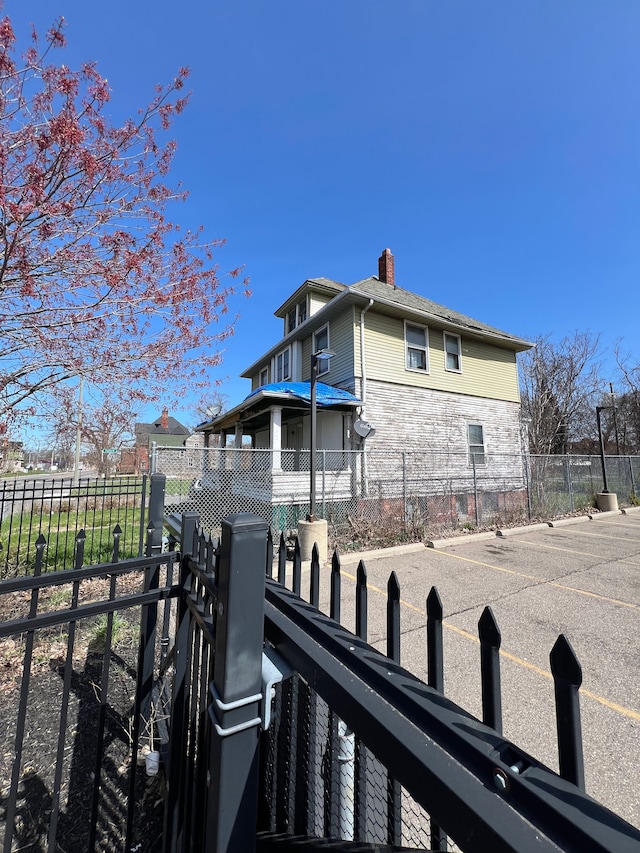 3674 Mount Elliott St, Detroit, MI 48207 - view of side of property featuring fence and a chimney