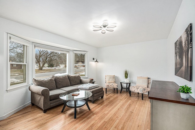 living area with baseboards and light wood finished floors