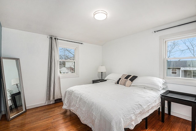 bedroom featuring lofted ceiling, baseboards, and wood finished floors