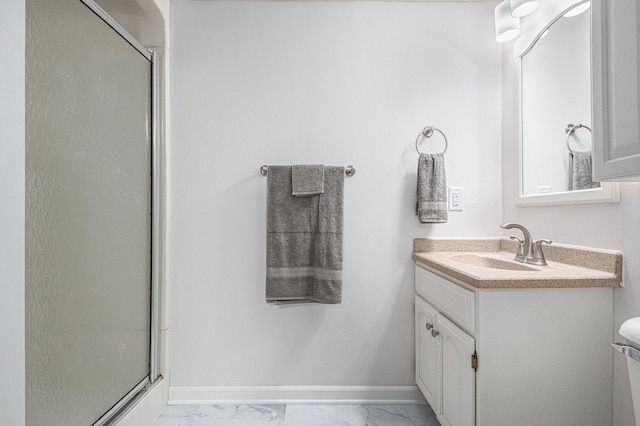 bathroom featuring marble finish floor, a shower stall, vanity, and baseboards