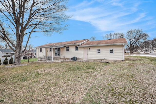 back of property featuring entry steps, a yard, and central air condition unit