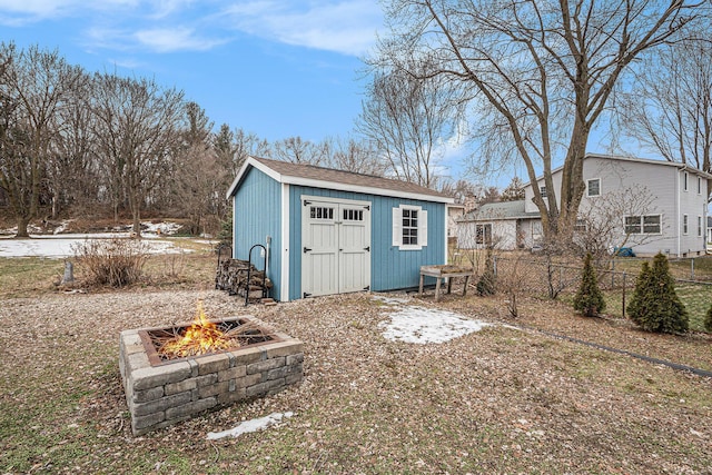 view of shed with a fire pit and fence