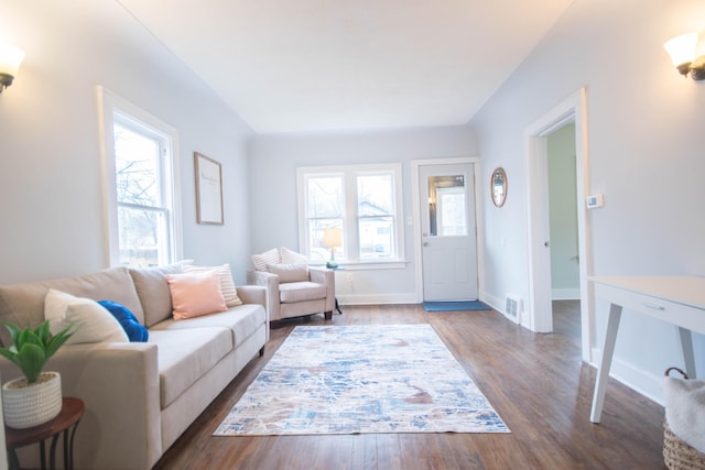 living room with baseboards, plenty of natural light, visible vents, and wood finished floors