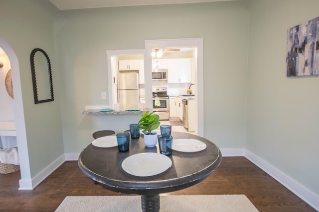 dining space featuring baseboards and wood finished floors