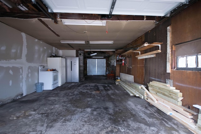 garage with freestanding refrigerator and wood walls