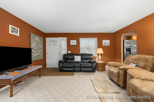 living room with carpet floors and arched walkways