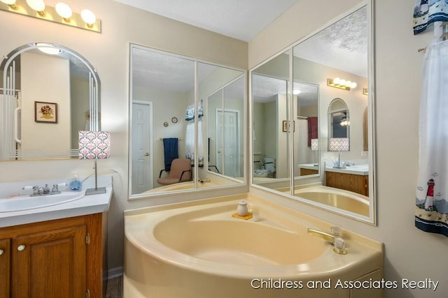 bathroom featuring toilet, two vanities, and a sink