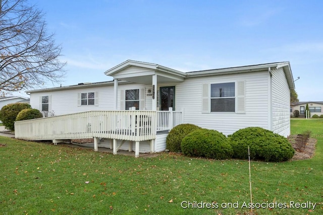 view of front facade featuring a front lawn and a wooden deck