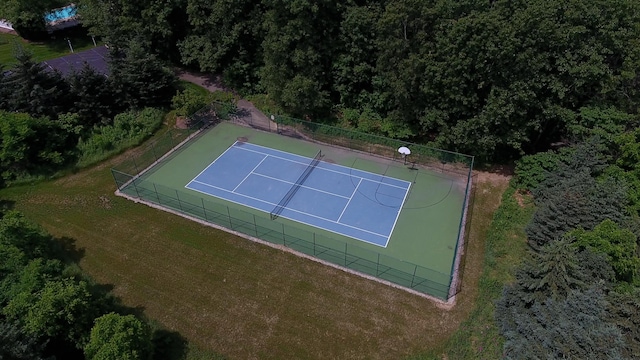 view of sport court with a yard and fence