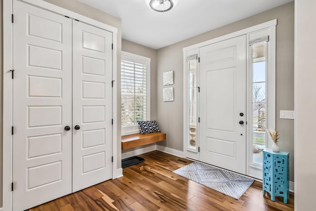 foyer entrance with baseboards and wood finished floors