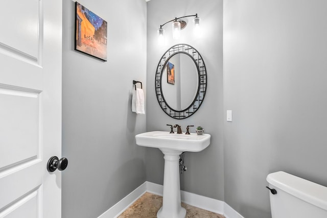 half bathroom with toilet and baseboards