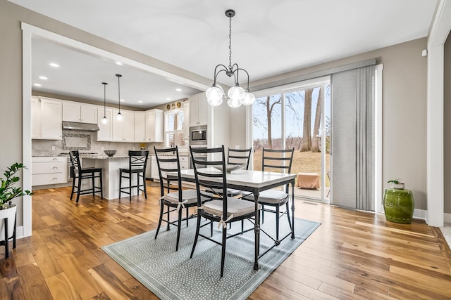 dining area featuring a chandelier, light wood-type flooring, and recessed lighting