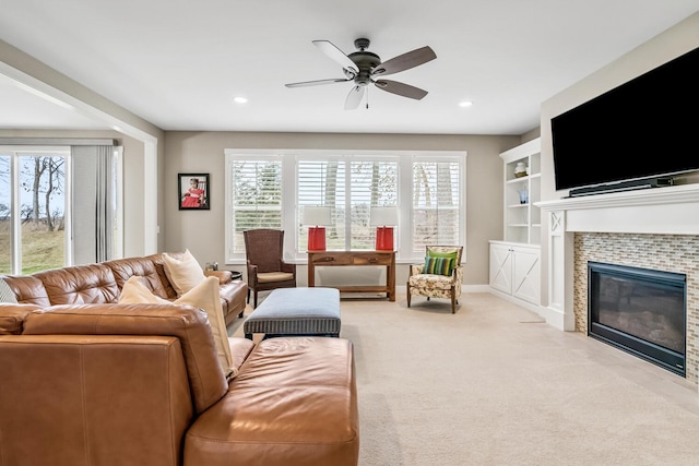 living room featuring a fireplace, recessed lighting, a ceiling fan, light carpet, and baseboards