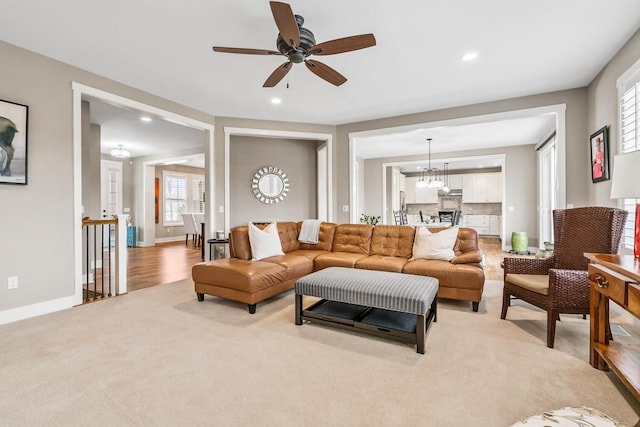 living area with recessed lighting, baseboards, a chandelier, and light colored carpet