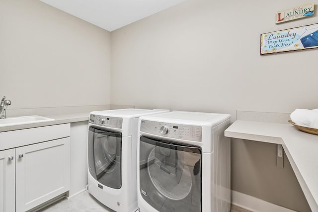 washroom featuring washer and clothes dryer, a sink, and cabinet space