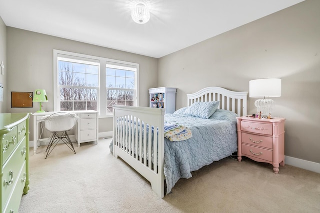 bedroom with baseboards and light colored carpet