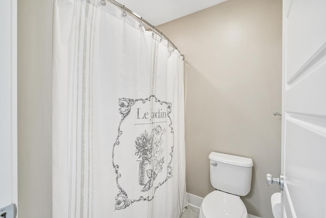 bathroom with curtained shower and toilet