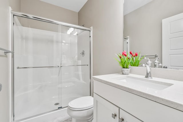 full bath featuring a stall shower, vanity, and toilet