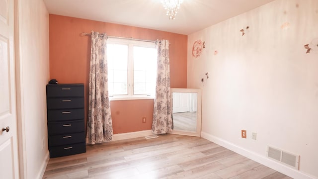 unfurnished bedroom featuring light wood-style floors, visible vents, and baseboards