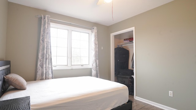 bedroom with dark wood-style flooring, ceiling fan, and baseboards