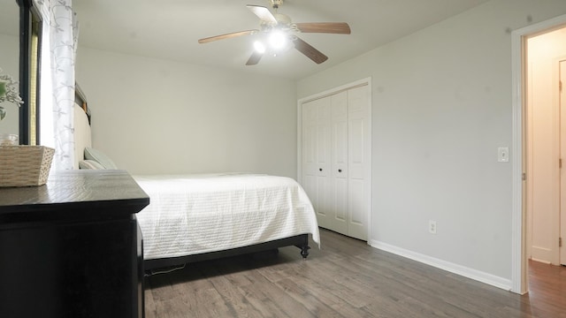 bedroom with a ceiling fan, a closet, baseboards, and wood finished floors