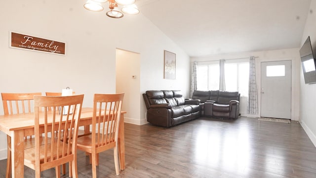 dining area featuring lofted ceiling, a notable chandelier, baseboards, and wood finished floors