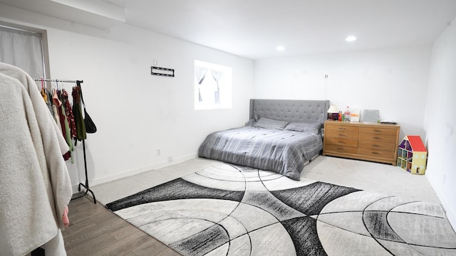 bedroom with baseboards, wood finished floors, and recessed lighting