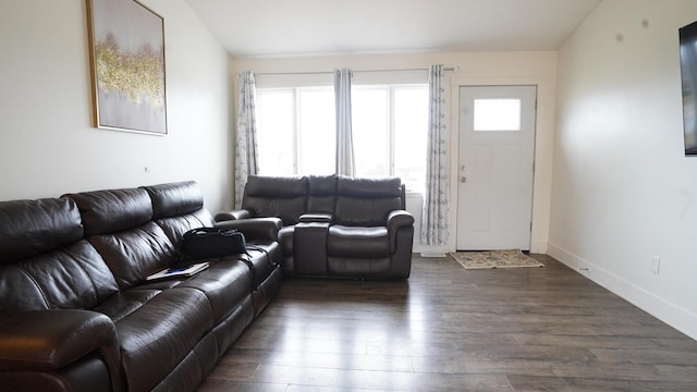 living room featuring lofted ceiling, baseboards, and dark wood-type flooring