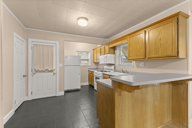 kitchen with a breakfast bar area, ornamental molding, a sink, white appliances, and a peninsula