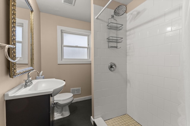 full bath with visible vents, a tile shower, vanity, and toilet