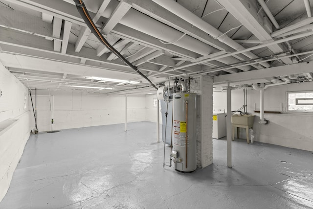 basement with washer / clothes dryer, gas water heater, and a sink