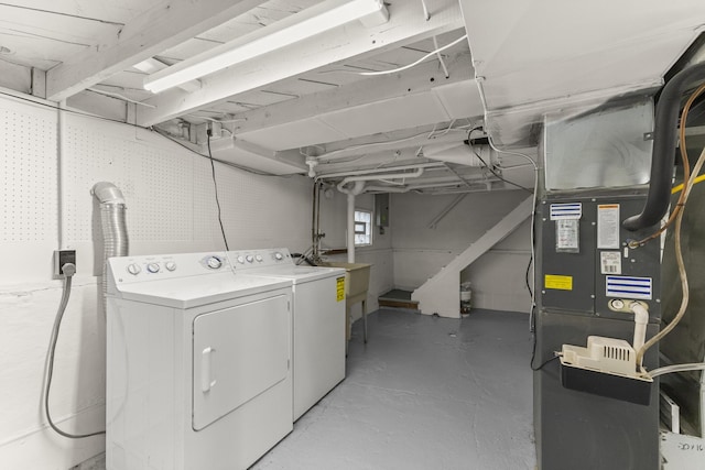 laundry room with heating unit, laundry area, and separate washer and dryer