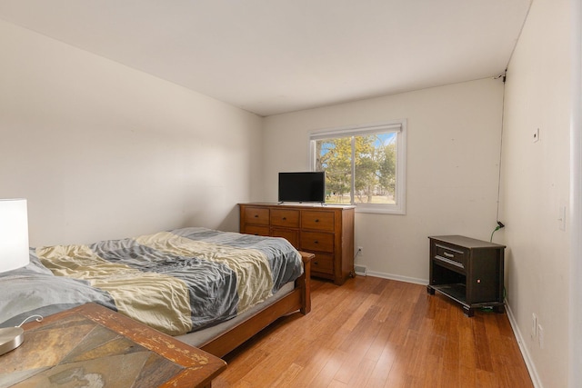 bedroom featuring light wood-style floors and baseboards