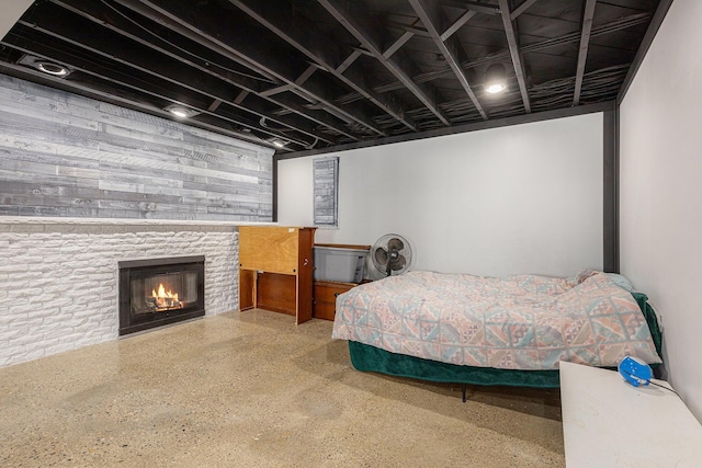 bedroom featuring a glass covered fireplace and speckled floor