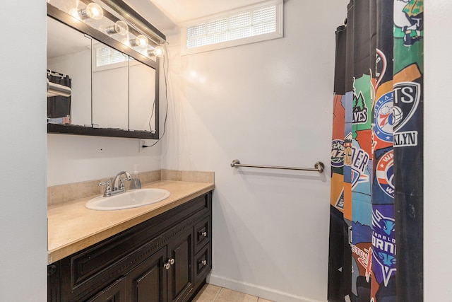 full bath with tile patterned flooring, baseboards, a wealth of natural light, and vanity