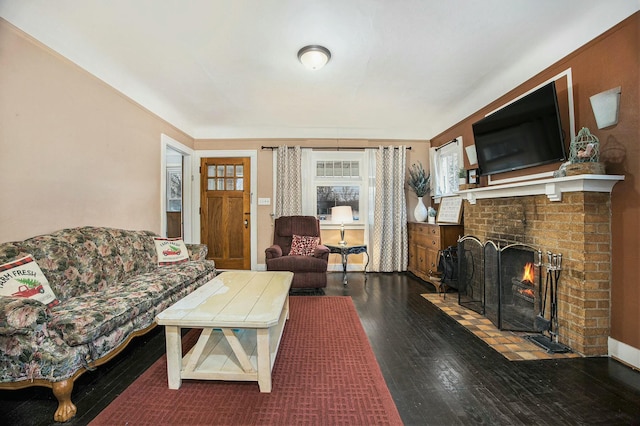 living area featuring a brick fireplace, wood-type flooring, and baseboards