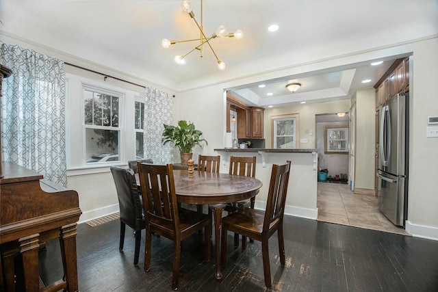 dining room featuring recessed lighting, a notable chandelier, wood finished floors, baseboards, and a raised ceiling