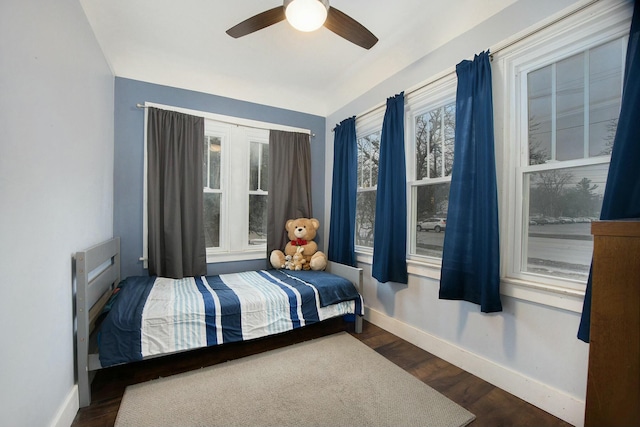 bedroom with a ceiling fan, baseboards, and dark wood-style flooring