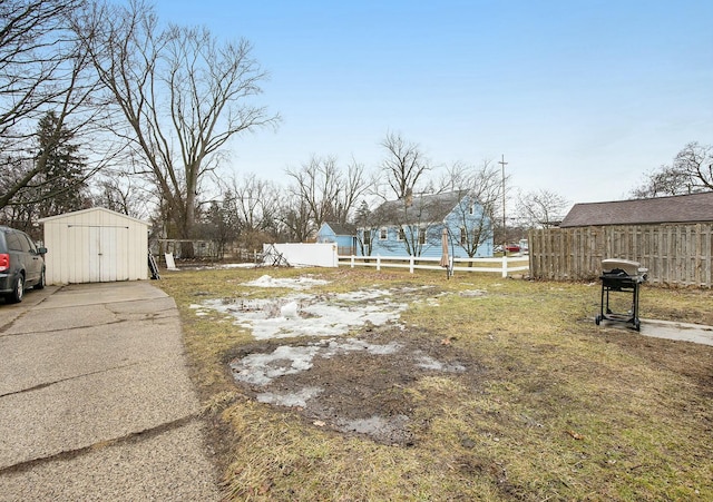 view of yard featuring an outdoor structure, fence, and a storage unit