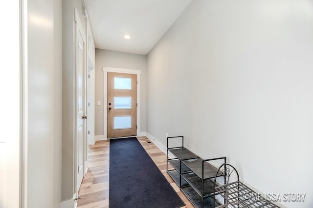 doorway with light wood finished floors, baseboards, and recessed lighting