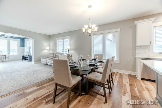 dining space featuring arched walkways, baseboards, and a healthy amount of sunlight