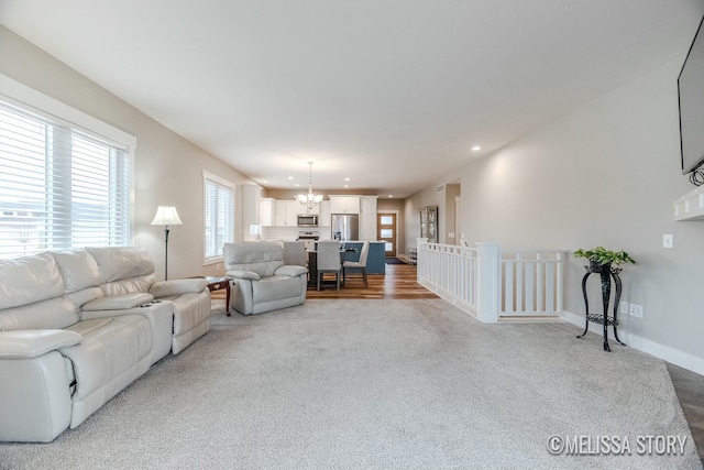 carpeted living room featuring baseboards, a chandelier, and recessed lighting