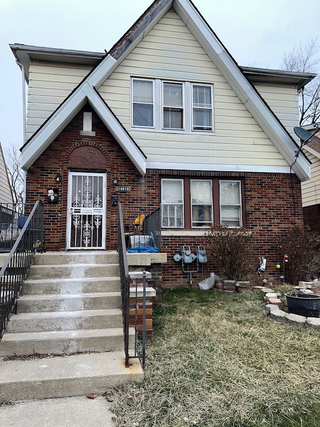 view of front of property featuring brick siding and a front lawn