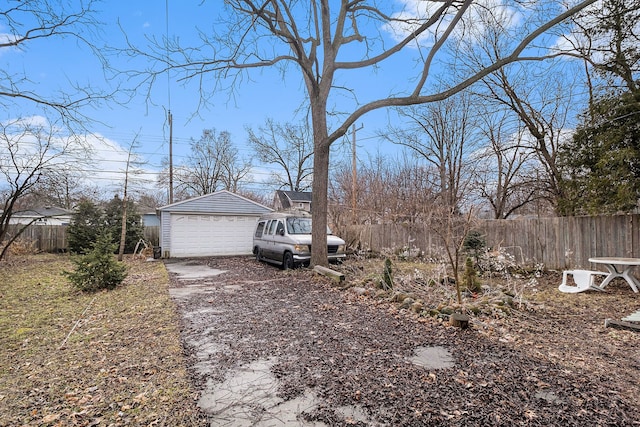 view of property exterior featuring a detached garage, fence, and an outdoor structure