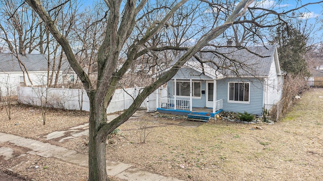 view of front of home with a porch and fence