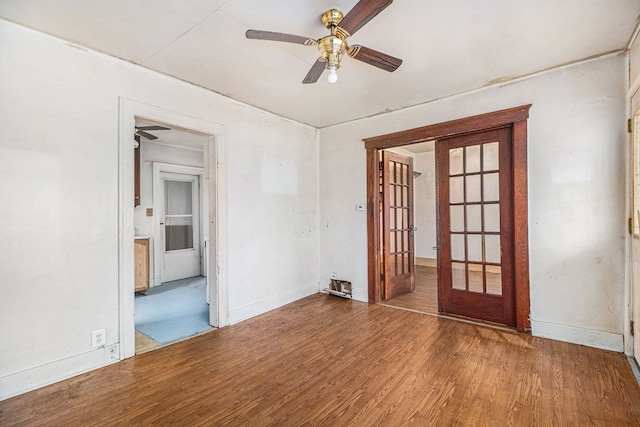 spare room with a ceiling fan, french doors, baseboards, and wood finished floors