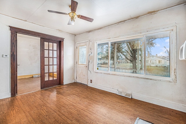 empty room featuring visible vents, baseboards, and wood finished floors