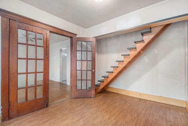 below grade area featuring stairs, french doors, and wood finished floors