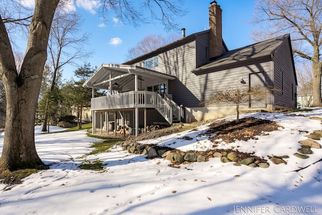 exterior space with stairs, a chimney, a deck, and a ceiling fan