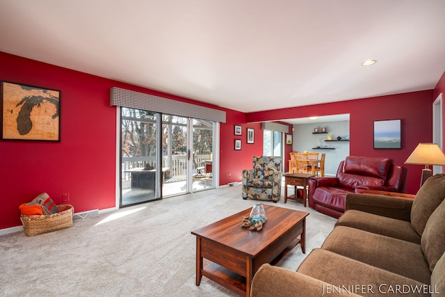 carpeted living area with an accent wall, recessed lighting, visible vents, and baseboards